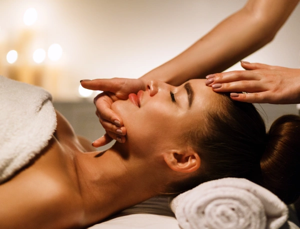 A woman getting her face washed by a masseuse.