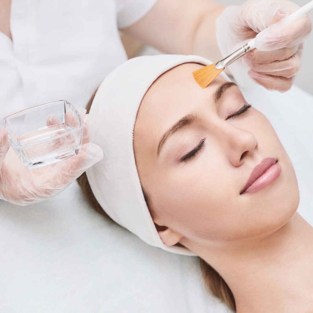 Custom Chemical Peel A woman getting her face painted with makeup.