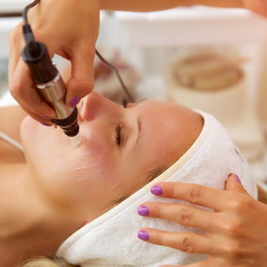 Microneedling + Booster Image A woman getting her face waxed at the spa