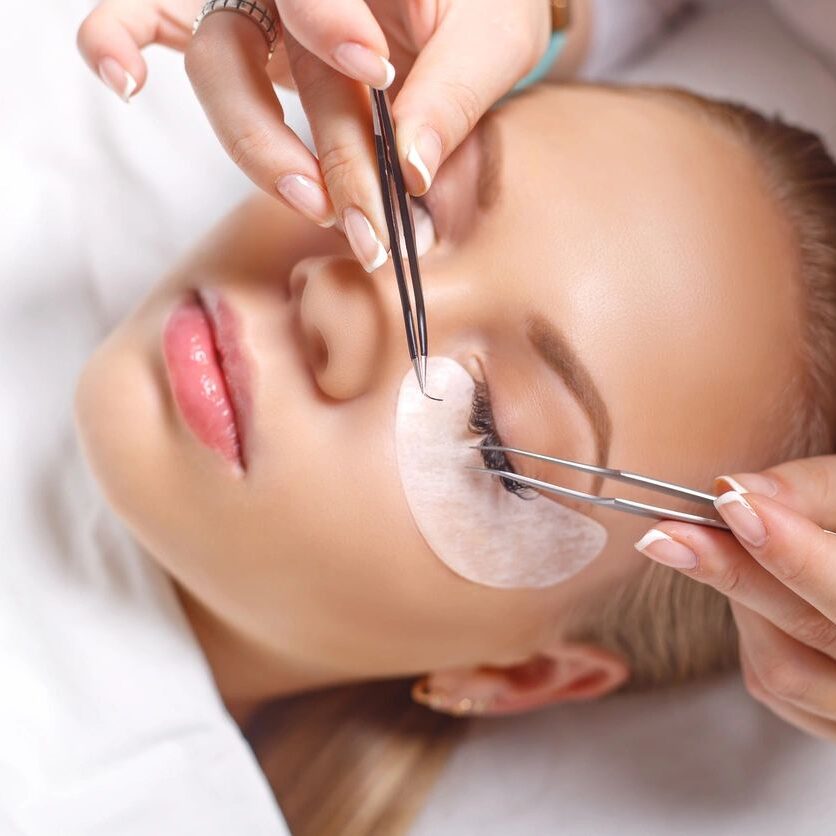 A woman getting her eyelashes cut off